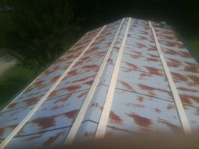 Rusted metal roof panels with new wood purlins before replacement — Storm Damage Roof Repair in Hampton Bays by Roofing Brothers